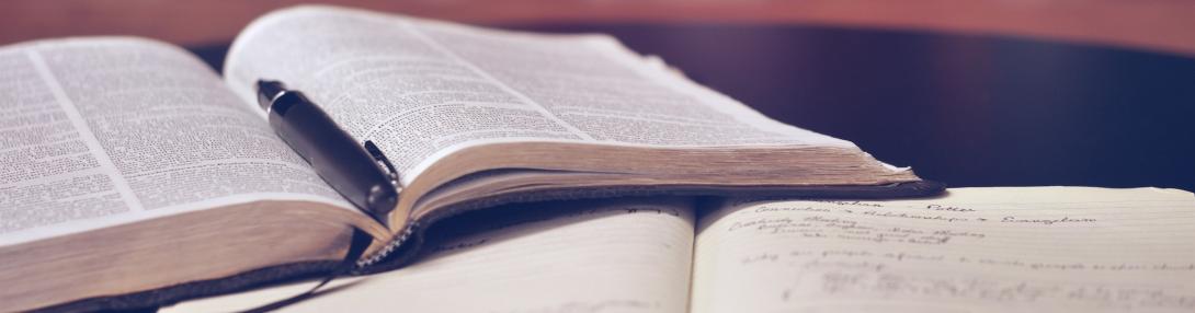 Open book with pen for essay writing